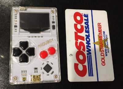 an arduboy next to a credit card